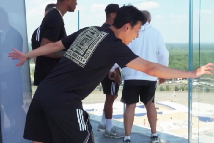 真恐高！孙兴慜在看台上一直往后退，慢慢往前探着身子看球场